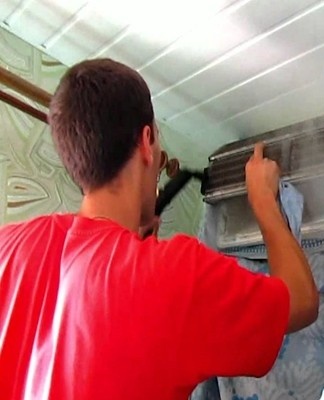 man maakt de airconditioner schoon