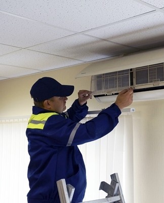 man installeert airconditioner