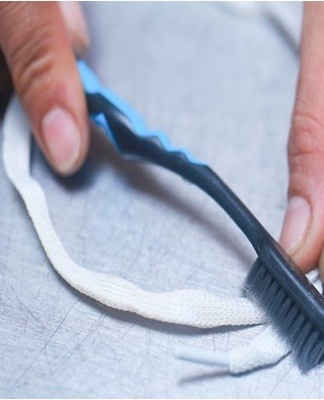 Vous devez mouiller les lacets, y appliquer du dentifrice et le répartir uniformément avec une brosse