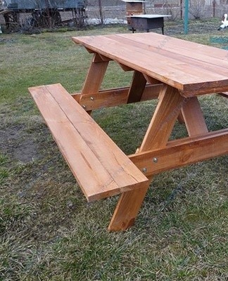 Een tuintafel met banken is gemaakt in de vorm van een monolithische structuur.