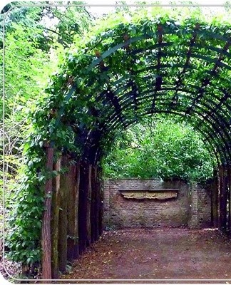 L'arc en treillis, entrelacé de verdure, transforme l'entrée en une autre décoration.