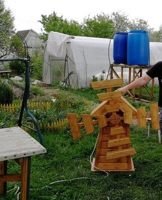 Des fleurs et des buissons bas sont plantés autour du moulin.