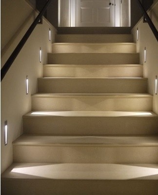 Pour les escaliers en plastique, il vaut la peine de choisir des luminaires de style moderne, avec un aspect et une forme laconiques.