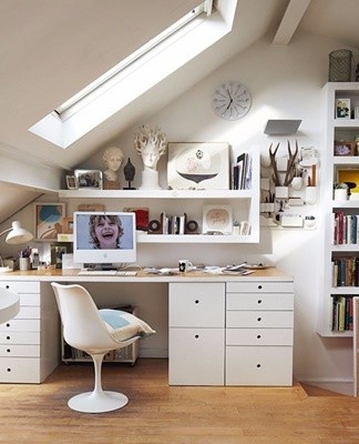 Un petit bureau est séparé du reste de la pièce par une étagère ou une armoire lumineuse.